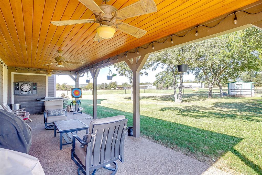 2608 Turkey Creek Road Mineral Wells, TX 76067 - Photo 33 of 39 a view of a patio with a table chairs and a backyard