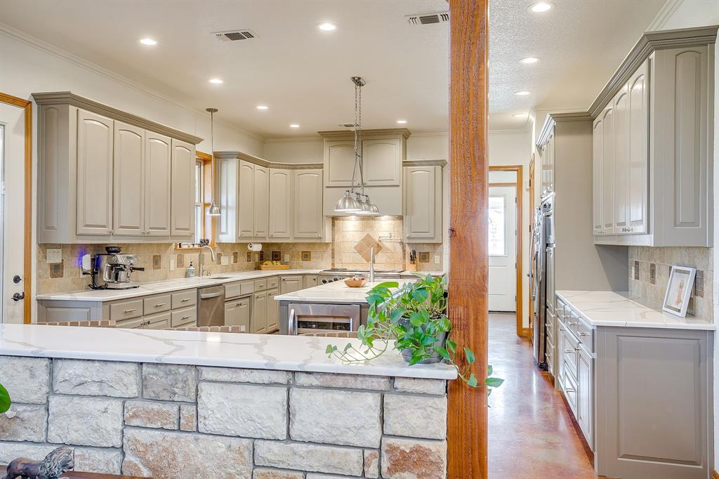 2608 Turkey Creek Road Mineral Wells, TX 76067 - Photo 10 of 39 a kitchen with stainless steel appliances kitchen island granite countertop a refrigerator a sink dishwasher and white cabinets with wooden floor