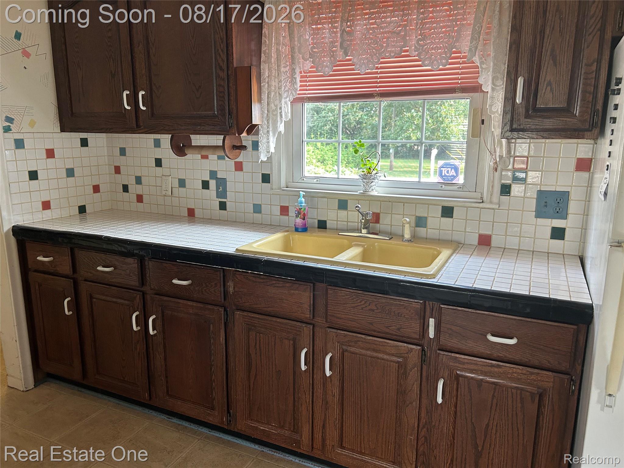 22967 Northline Road Taylor, MI 48180 - Photo 12 of 22 Kitchen featuring wood-finish cabinetry, tile countertops, and a double basin sink