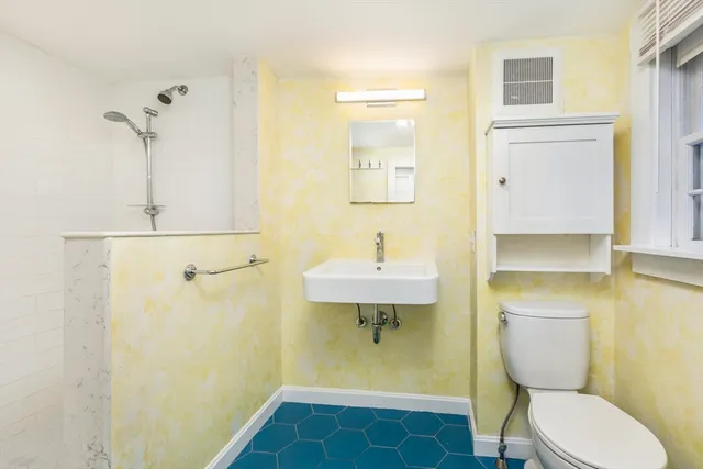 a bathroom with a sink a toilet and shower