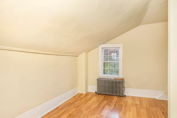 a view of a room with wooden floor and small window