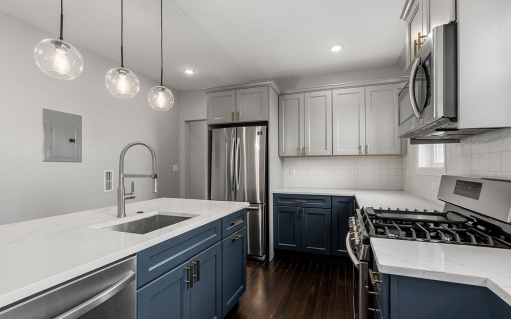 101 Draper Street, Unit 2 Boston, MA 02122 - Photo 4 of 19 a kitchen with stainless steel appliances a sink stove and cabinets