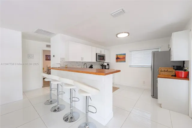 a kitchen with stainless steel appliances a stove a sink and a refrigerator