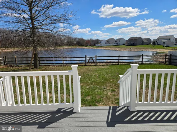 a view of a house with a small deck and a large tree