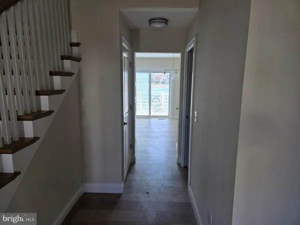 a view of a hallway with wooden floor and entryway