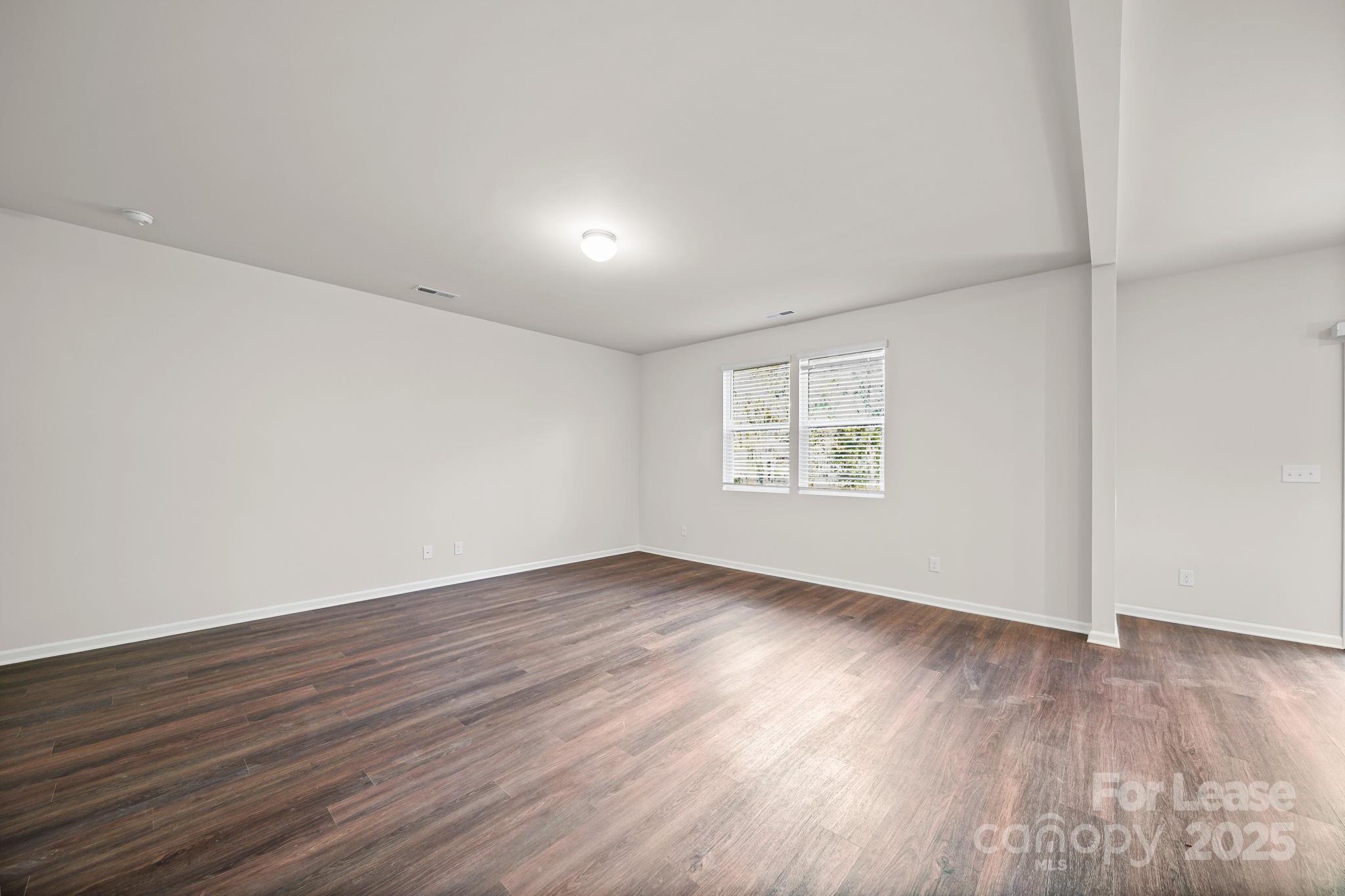 3200 Polk And White Road, Unit A Charlotte, NC 28269 - Photo 22 of 35 an empty room with wooden floor and windows