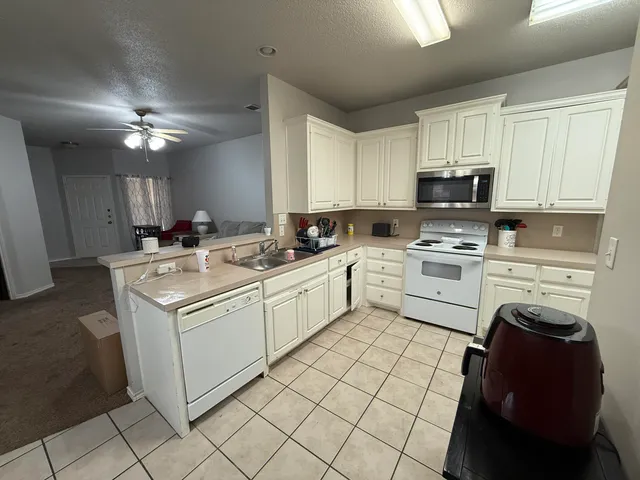 a kitchen with a sink cabinets and white appliances