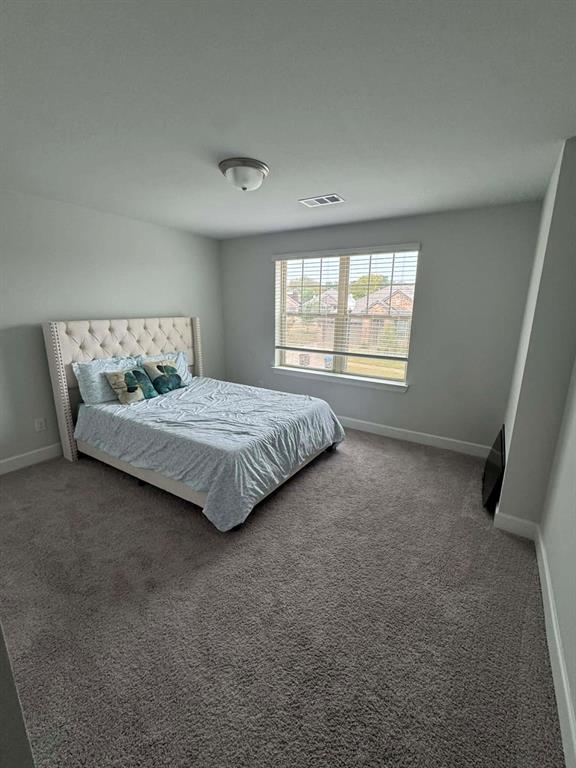 8628 Spindletop Drive Fort Worth, TX 76120 - Photo 15 of 21 a spacious bedroom with a bed and a window