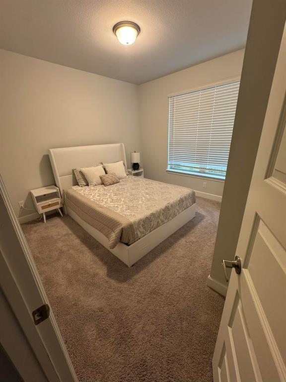 8628 Spindletop Drive Fort Worth, TX 76120 - Photo 16 of 21 a bed sitting in a room next to a window