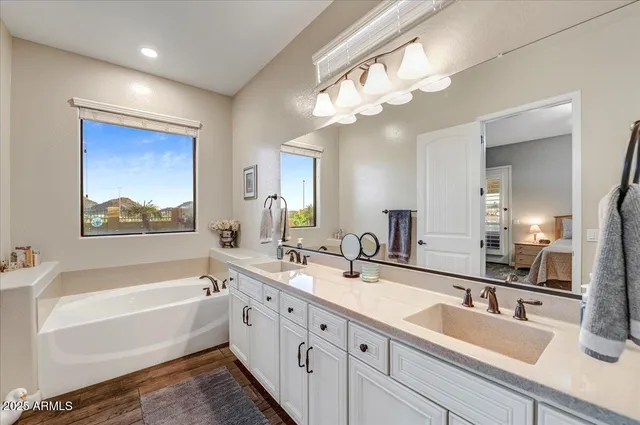 a spacious bathroom with a double vanity sink mirror and shower