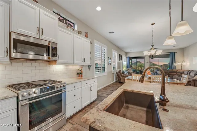 a kitchen with stainless steel appliances granite countertop a stove and a microwave