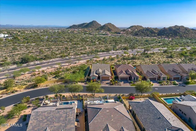 an aerial view of residential houses with outdoor space and trees