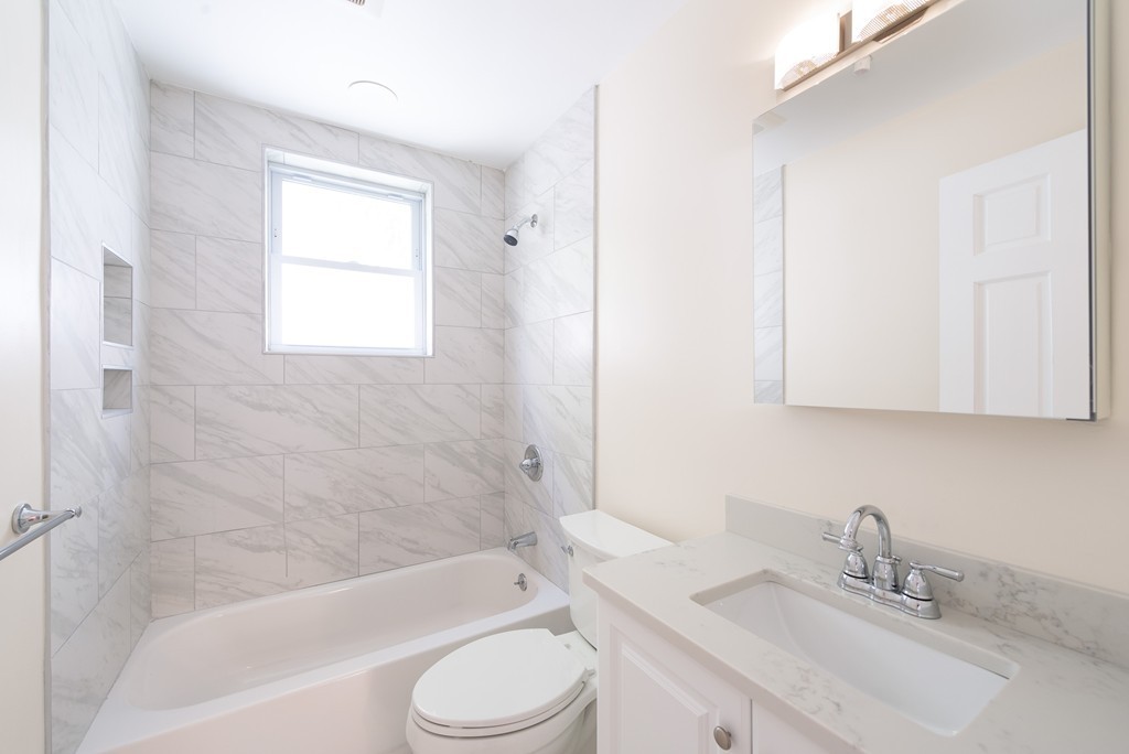180 Magazine Street, Unit 2 Cambridge, MA 02139 - Photo 11 of 20 a bathroom with a bathtub shower sink vanity mirror and toilet