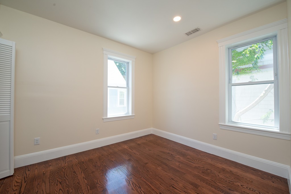 180 Magazine Street, Unit 2 Cambridge, MA 02139 - Photo 9 of 20 an empty room with wooden floor and windows