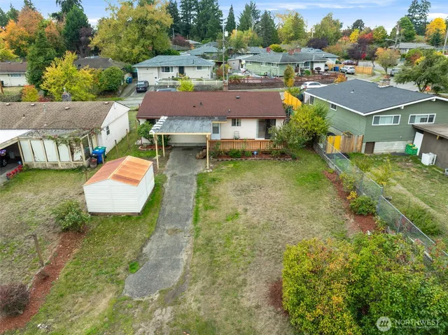 an aerial view of residential houses with outdoor space and trees