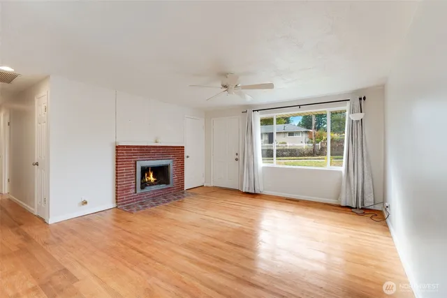 a view of an empty room with window and fire place