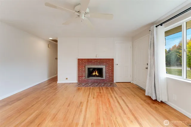 a view of an empty room with a fireplace and a window