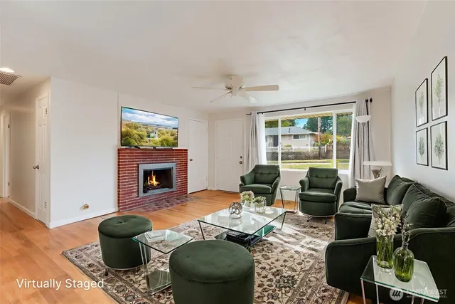 a living room with furniture a fireplace and a floor to ceiling window