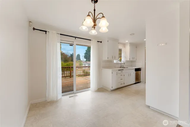 a view of a kitchen with refrigerator and a sink
