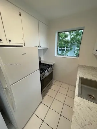 a kitchen with a stove a refrigerator and a sink