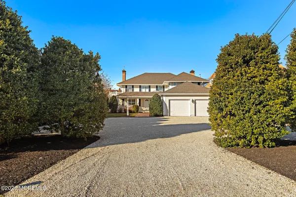 a view of a large house with a big yard and large trees