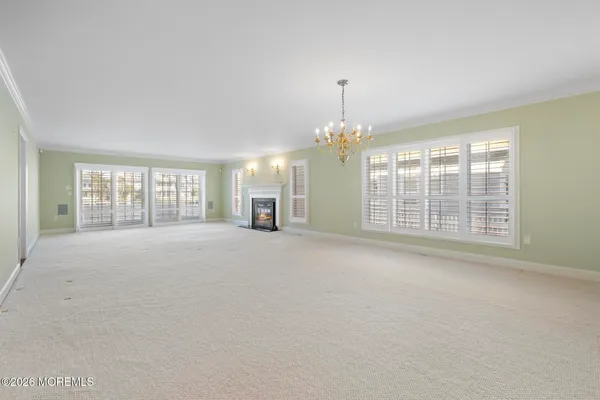 a large kitchen with stainless steel appliances kitchen island granite countertop a stove a sink and white cabinets with wooden floor