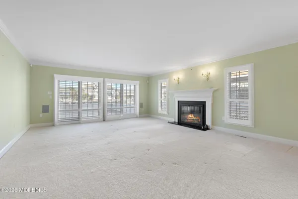 a large kitchen with kitchen island a stove a sink a refrigerator and white cabinets with wooden floor