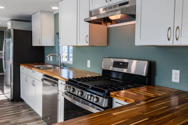 a kitchen with stainless steel appliances granite countertop a stove and a refrigerator