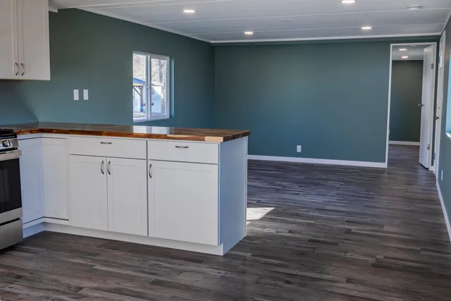 a kitchen with granite countertop a sink and a wooden floor