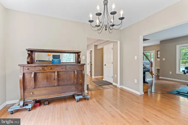 a living room with hard wood floors and a chandelier
