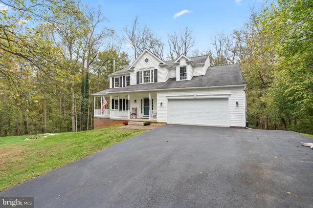 a front view of a house with a garden and trees