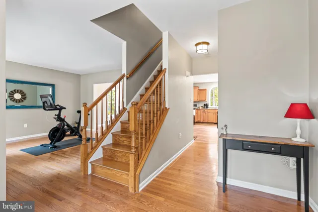 a view of a hallway with wooden floor and a living room