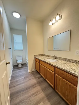 a spacious bathroom with a granite countertop sink and a mirror