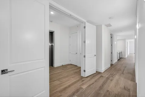 a view of a hallway with wooden floor
