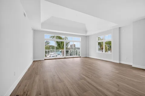 a view of a big room with wooden floor windows and cabinet