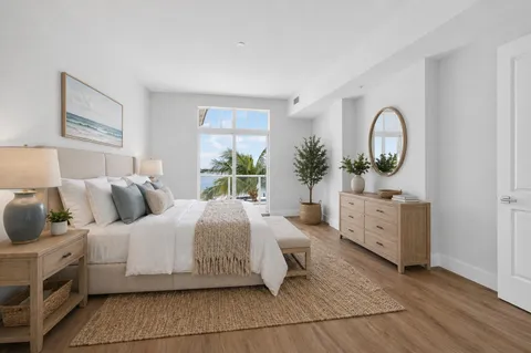 a bedroom with a bed and a dresser next to a window