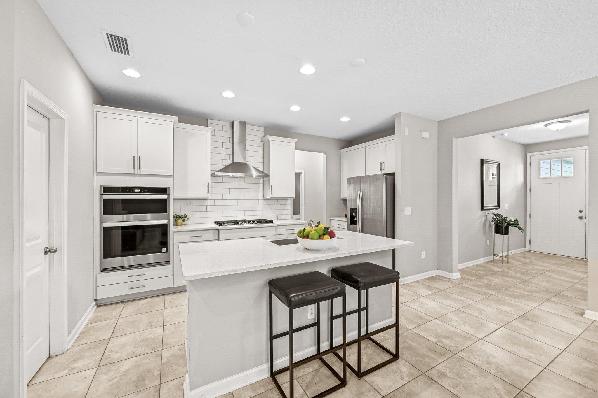 75 Pinzon Place St. Augustine, FL 32095 - Photo 7 of 51 a kitchen with kitchen island a stove a table and chairs