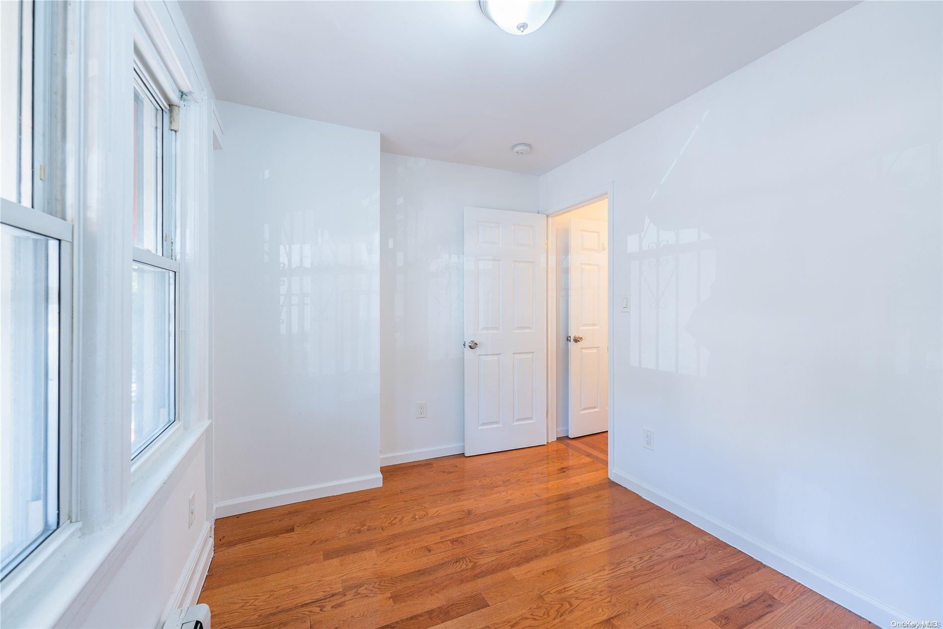 55-15 96th Street Queens, NY 11368 - Photo 15 of 31 a view of empty room with wooden floor and fan