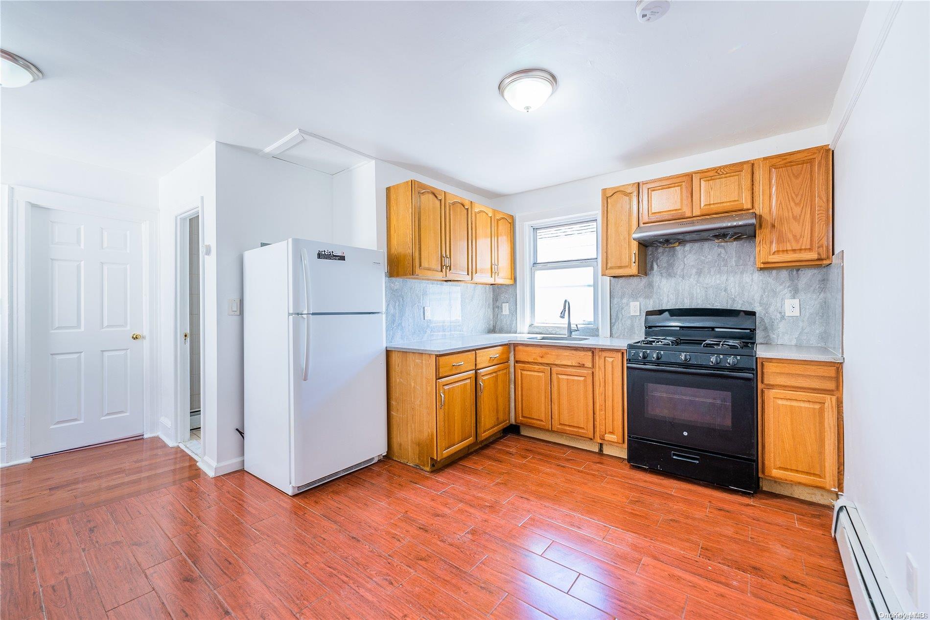 55-15 96th Street Queens, NY 11368 - Photo 16 of 31 a kitchen with stainless steel appliances granite countertop a stove a sink and a refrigerator