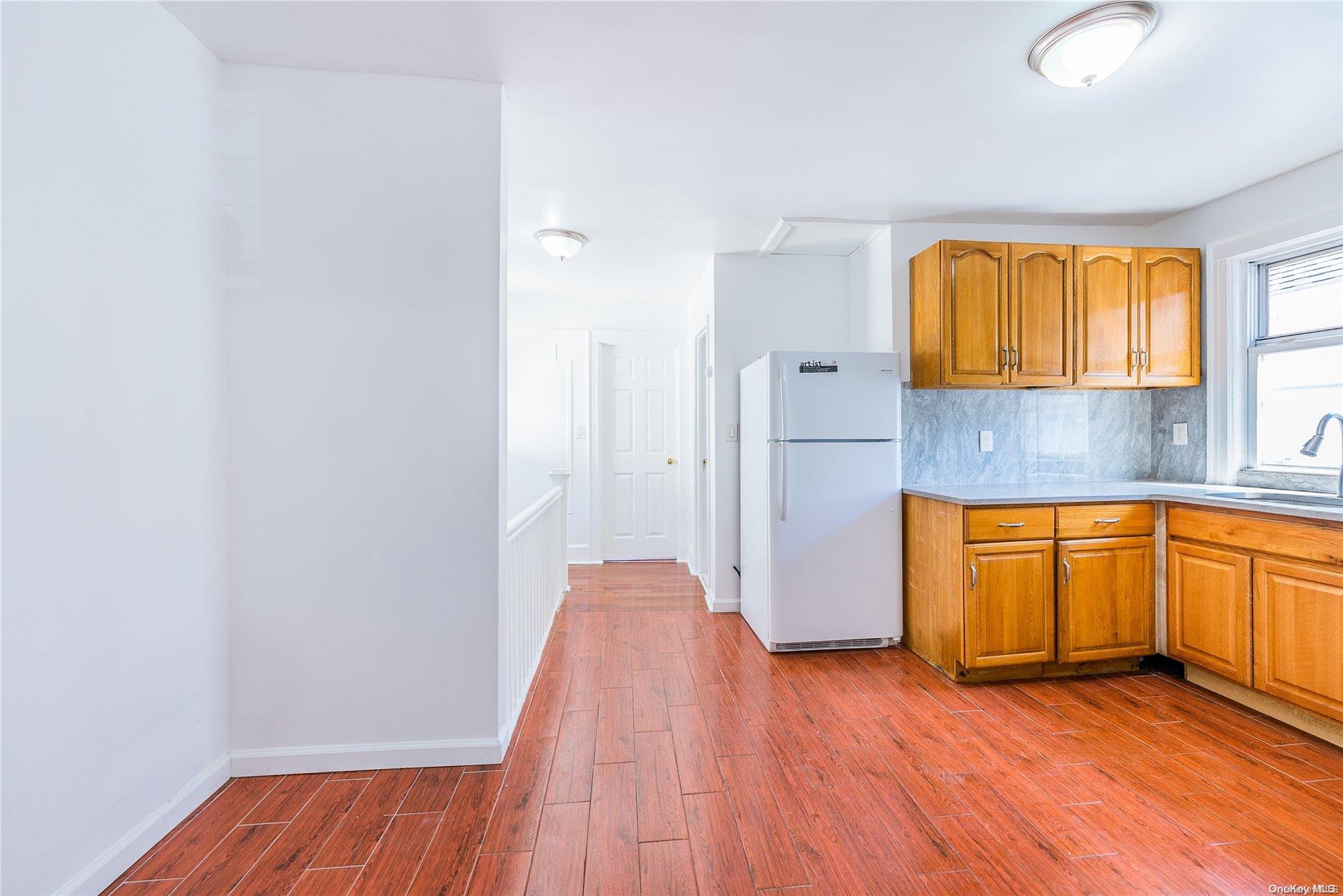 55-15 96th Street Queens, NY 11368 - Photo 18 of 31 an empty room with wooden floor and windows
