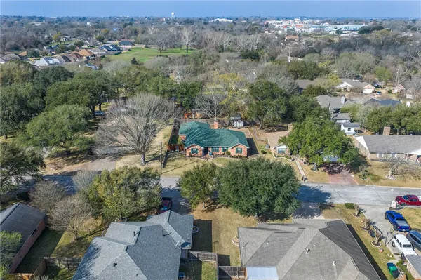 an aerial view of residential house with outdoor space and trees all around