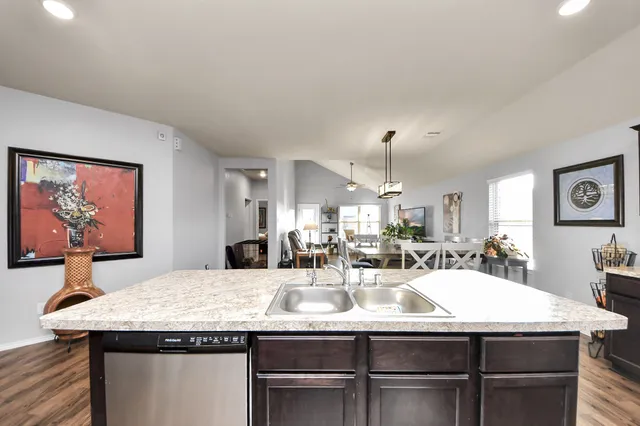 a living room with furniture and a flat screen tv with kitchen view