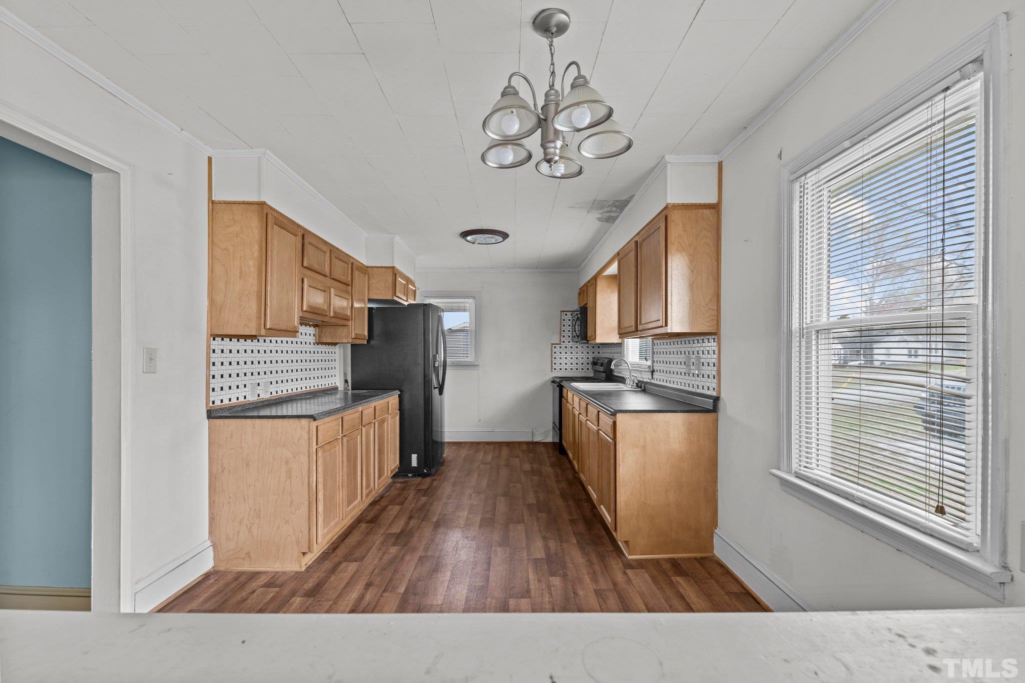 293 Cavel Chub Lake Road Roxboro, NC 27574 - Photo 10 of 15 a kitchen with stainless steel appliances granite countertop a refrigerator a sink dishwasher a stove and a dining table with wooden floor