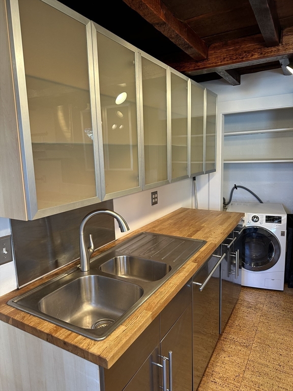 18 Tremont Street, Unit 2 Cambridge, MA 02139 - Photo 3 of 14 a kitchen with a sink and a cabinet with a granite countertops