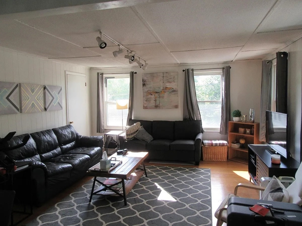 18 Tremont Street, Unit 2 Cambridge, MA 02139 - Photo 4 of 14 a living room with furniture a rug and a window