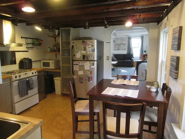 a kitchen with a table chairs refrigerator and cabinets
