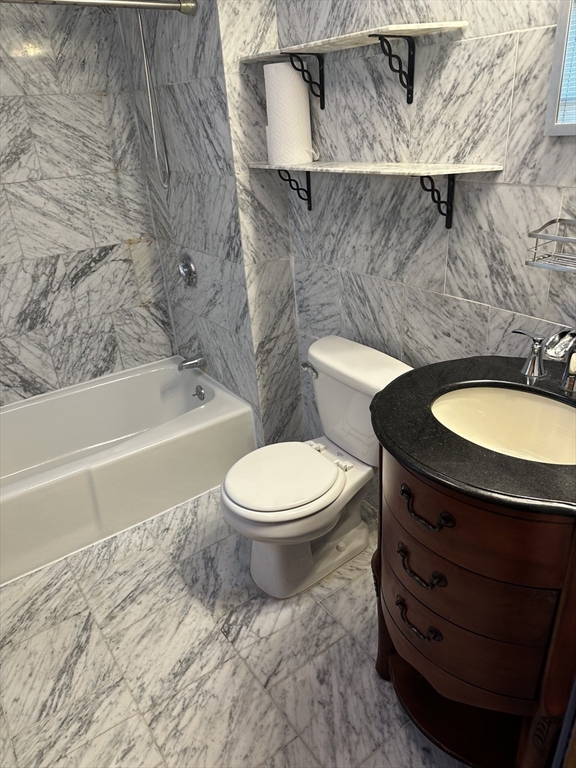 18 Tremont Street, Unit 2 Cambridge, MA 02139 - Photo 9 of 14 a bathroom with a granite countertop toilet and a sink