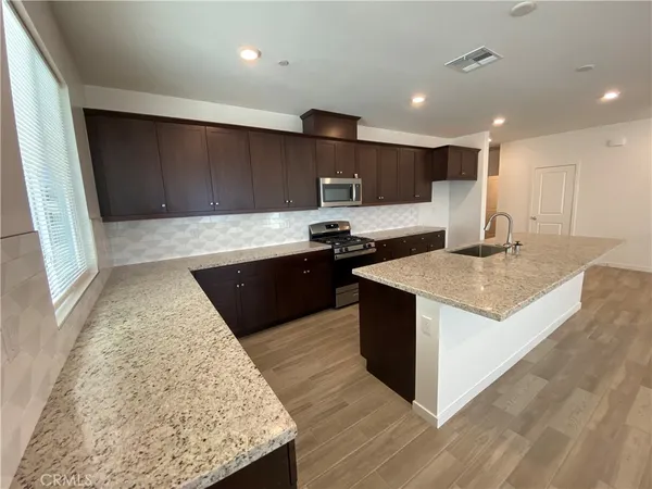 a kitchen with stainless steel appliances granite countertop a sink and a stove