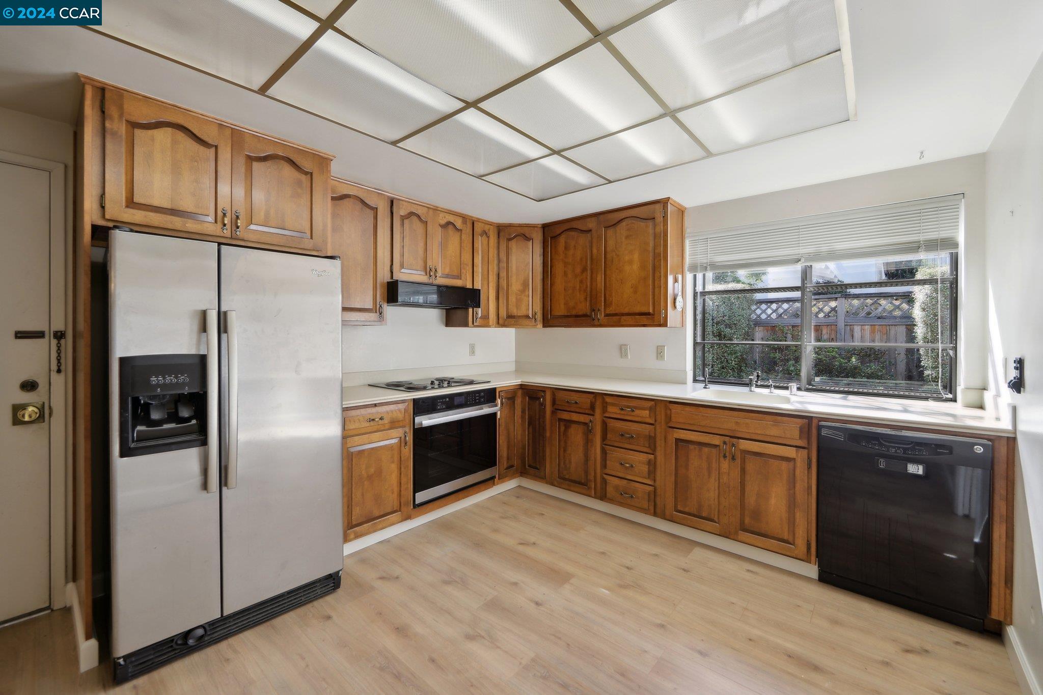 826 Augusta Drive Moraga, CA 94556 - Photo 14 of 35 a kitchen with stainless steel appliances granite countertop a refrigerator a sink dishwasher a stove with wooden cabinets and floors