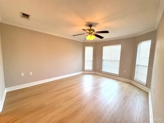 a view of an empty room with a window and wooden floor